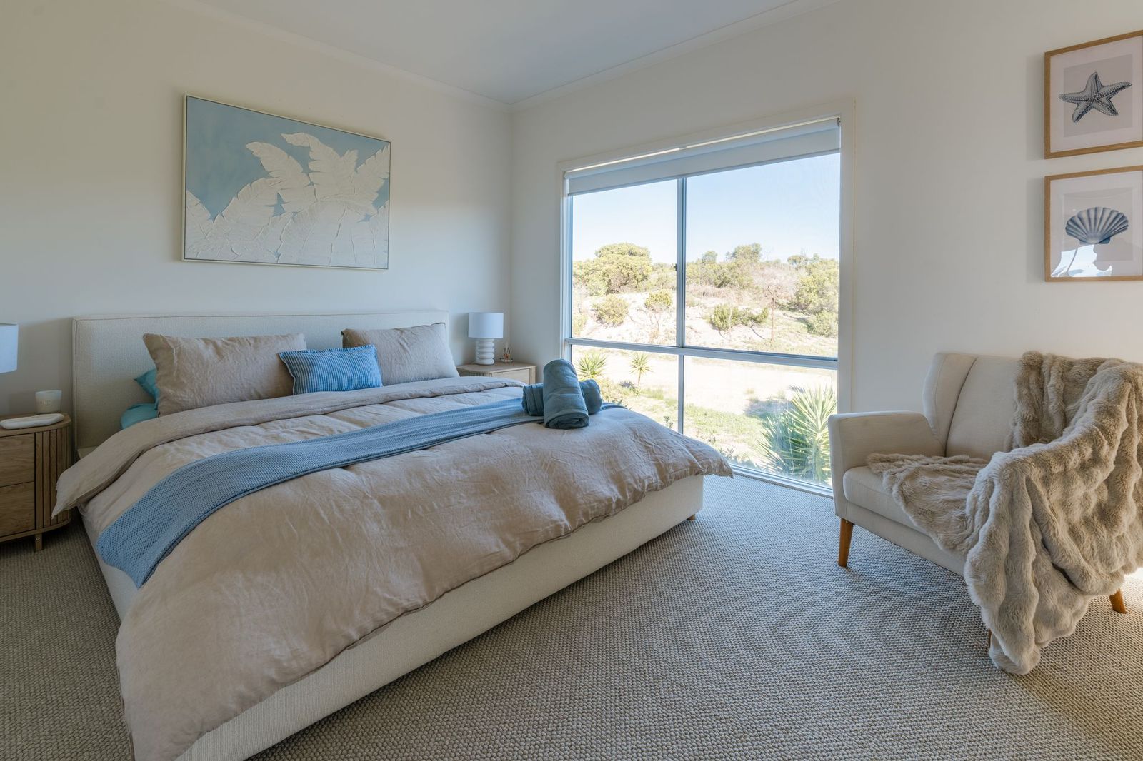 Sunlit main bedroom with king bed and garden views
